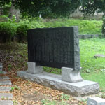 昭和62年、墓の脇に「竹橋事件」の石碑が建つ。裏面には処刑された55名と事件当日自死した1名の名が刻まれている。ようやく、彼らに対する鎮魂の気運が高まってきた