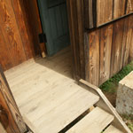 木の階段を3つ上がると緑のドア。内側に開き、客人を招き入れる